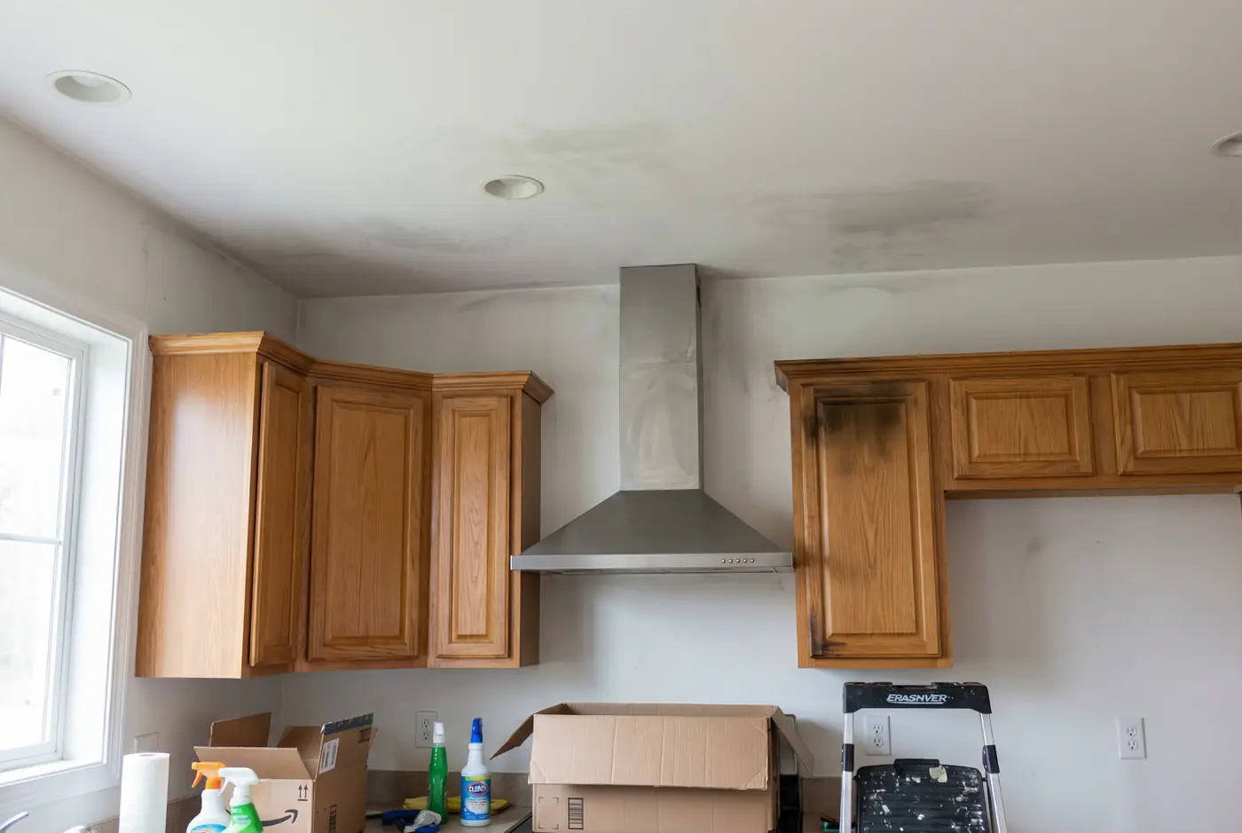 Smoke and soot cleanup technician cleaning fire-damaged kitchen in Phoenix AZ